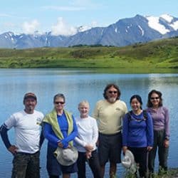hikers in front of a lake in alaska