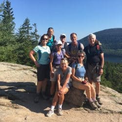 Group of hikers pose on a trail in Acadia National Park