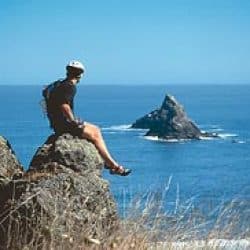 man sitting on an ocean overlook