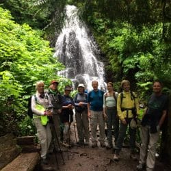 hikers in front of a waterfall