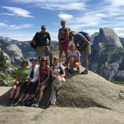 Group of hikers pose from a mountain top in Yosemite National Park