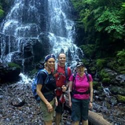 hikers in front of a waterfall